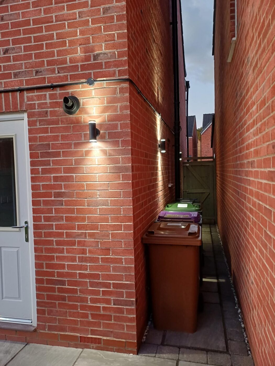 Outdoor lighting along a side passage seen during the day
