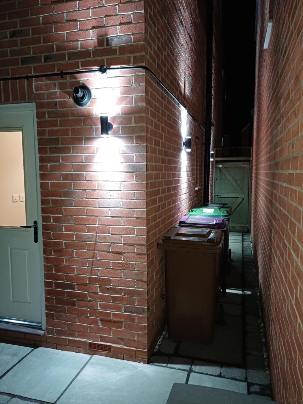The same side passage lit up at night by the installed lights