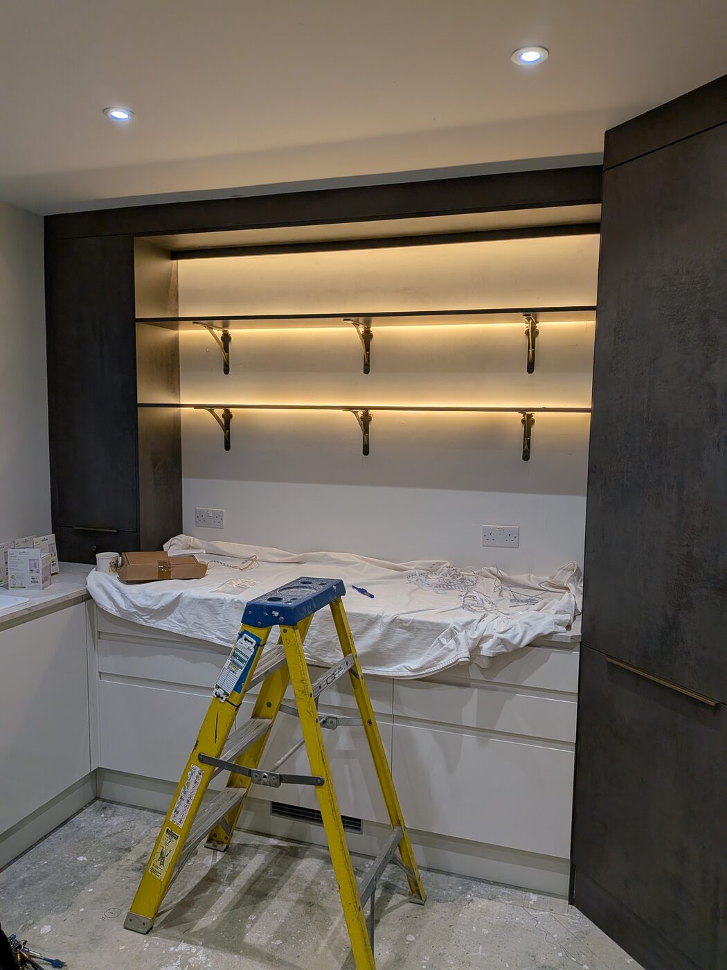 LED strip lighting fitted under kitchen shelving alongside ceiling downlights