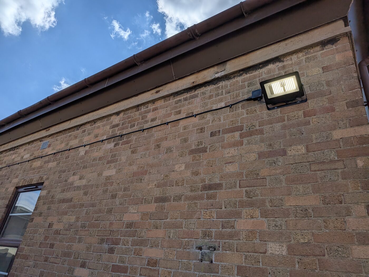Outdoor security floodlight installed on the side of a building