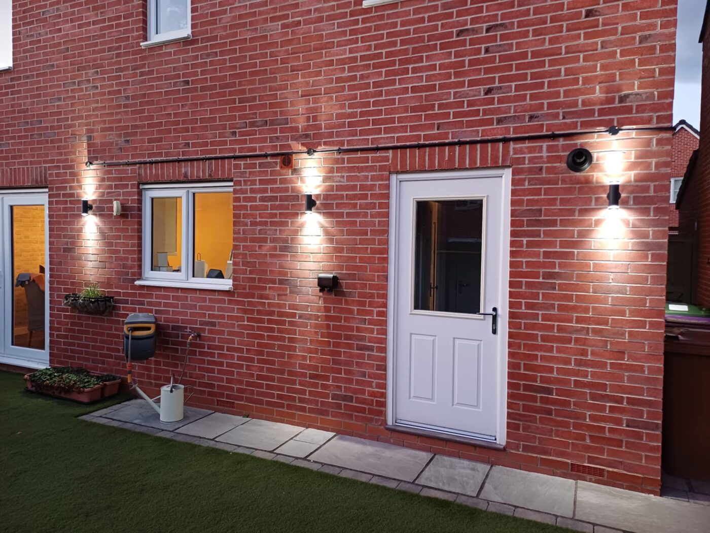 Outdoor wall lights installed at dusk on a Lincoln property