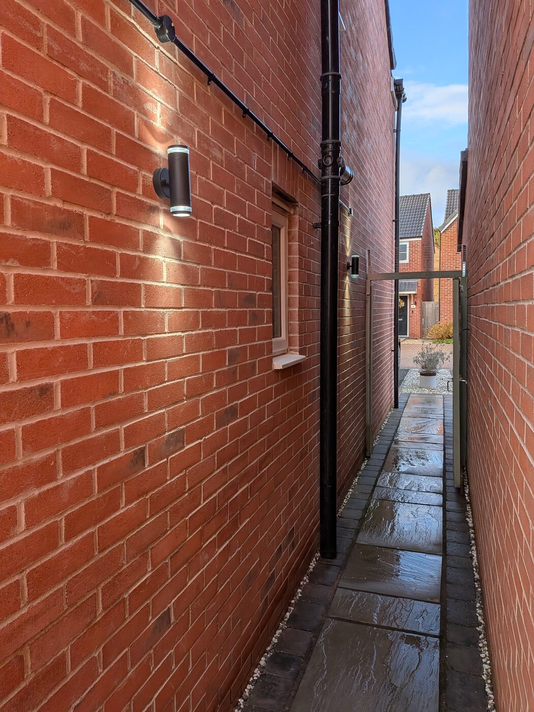 Outdoor wall light fitted along the side passage of a property